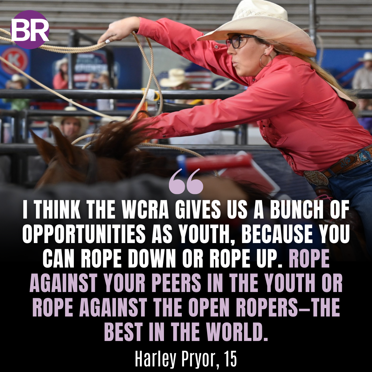 Teenage roper in pink shirt and cowboy hat swings lasso while competing in rodeo event at arena with spectators in background