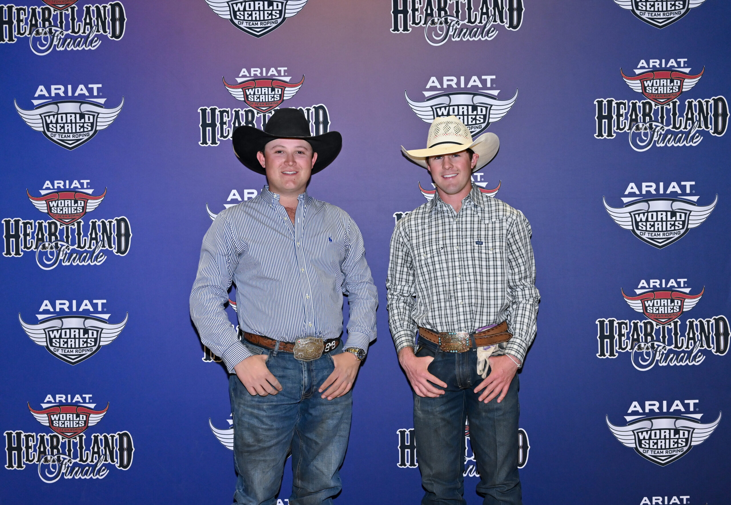 Two men in cowboy hats and Western shirts pose at the ARIAT World Series of Team Roping Heartland Finale event